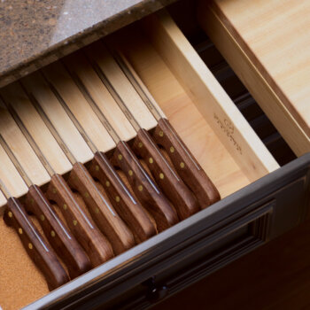 A knife block to store cutlery inside a kitchen drawer.